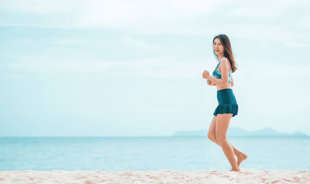 woman running on beach to treat spider veins