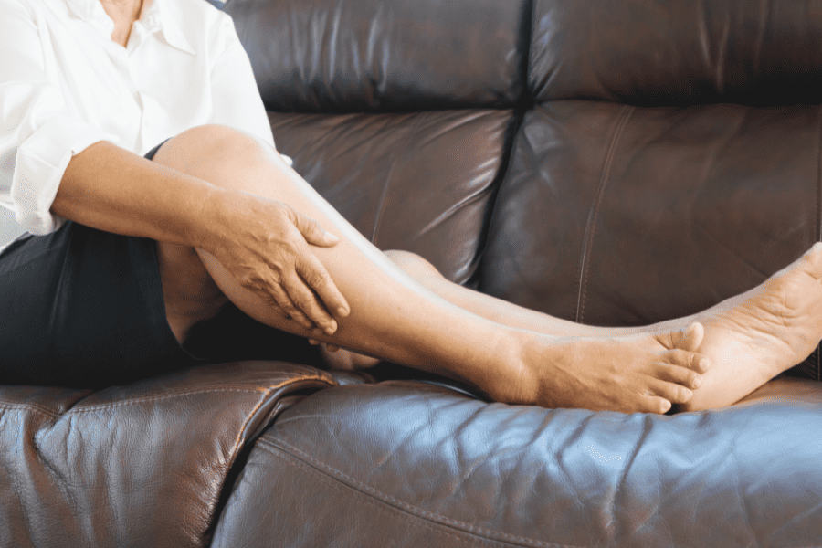 person massaging swollen leg
